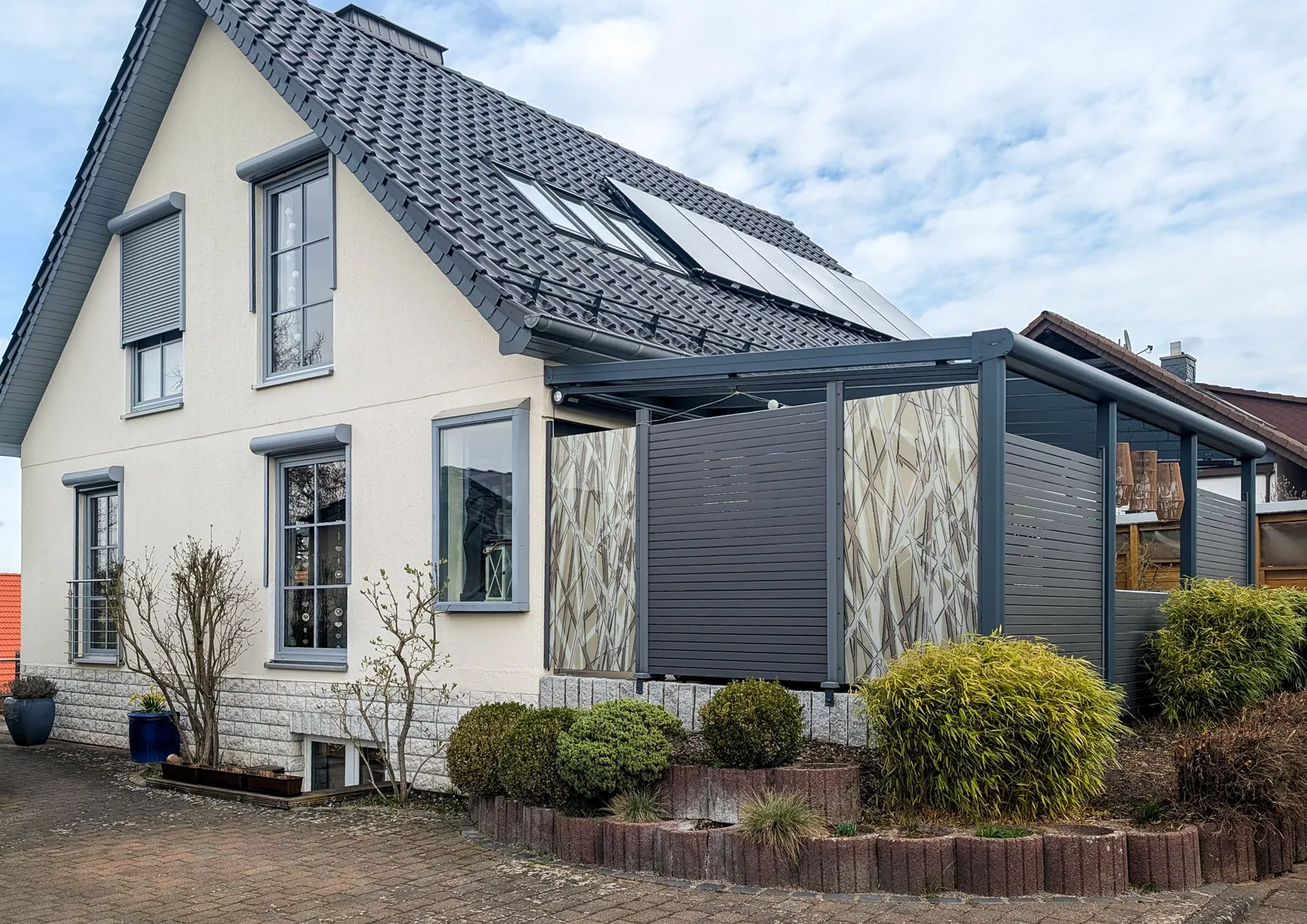 Sichtschutz aus WPC und Glas mit Motiv an einer Terrasse am Haus