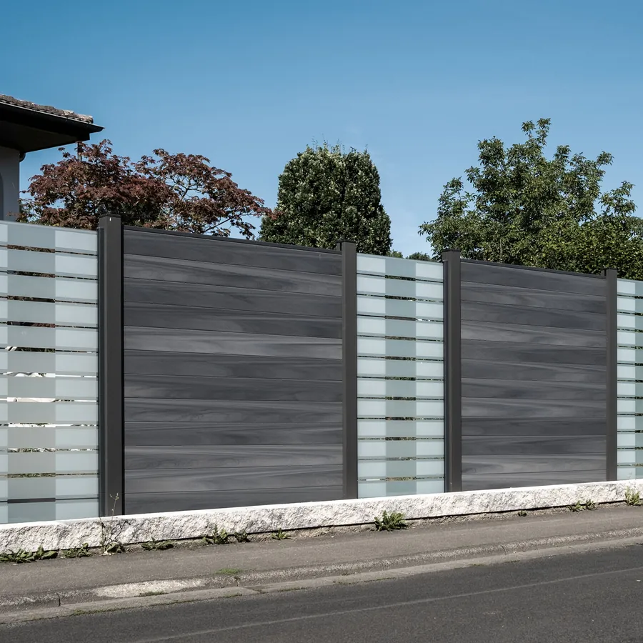 Grauer WPC-Zaun mit Glasstreifen entlang einer Straße