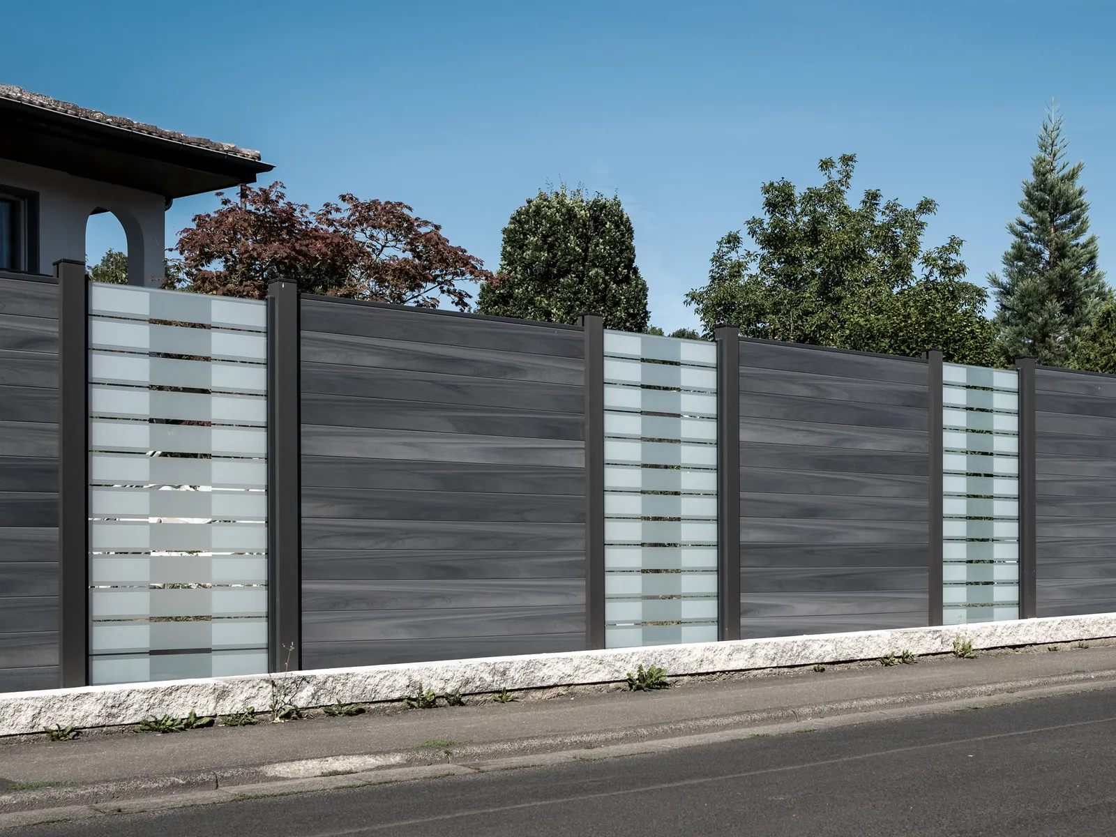 WPC-Zaun mit Glasstreifen als Sichtschutz an der Grundstücksgrenze zur Straße